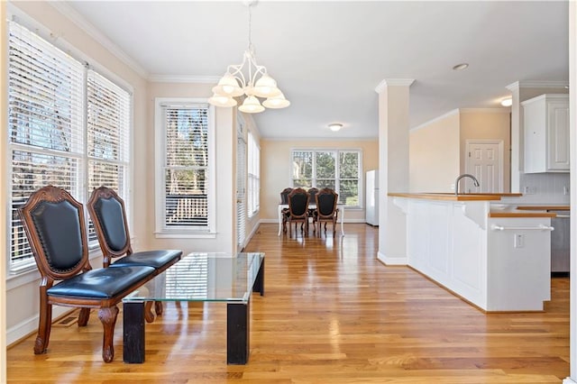 interior space with decorative light fixtures, light hardwood / wood-style flooring, a notable chandelier, white cabinets, and white fridge