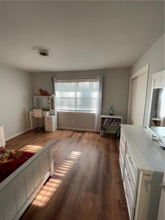 unfurnished bedroom with a closet and dark wood-type flooring