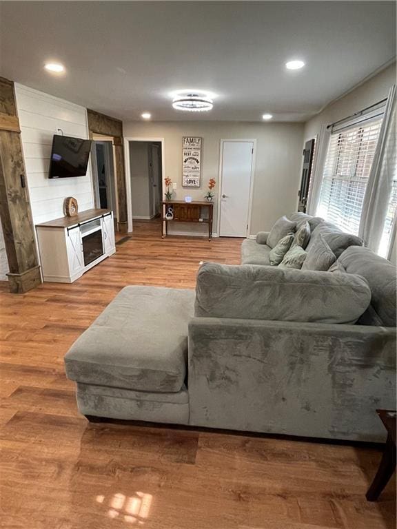 living room featuring a fireplace, wood finished floors, and recessed lighting