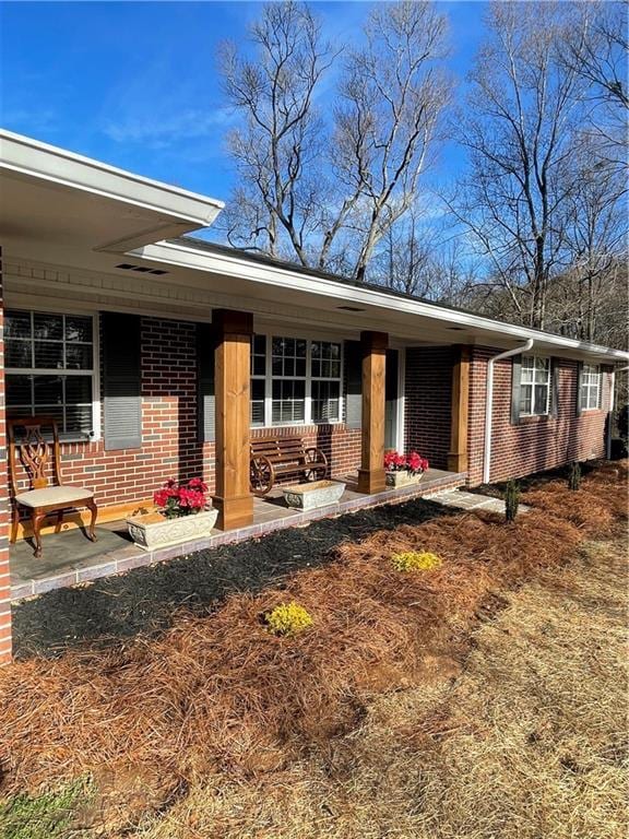 view of front facade featuring covered porch and brick siding