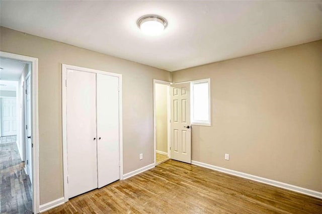 unfurnished bedroom with light wood-type flooring and a closet