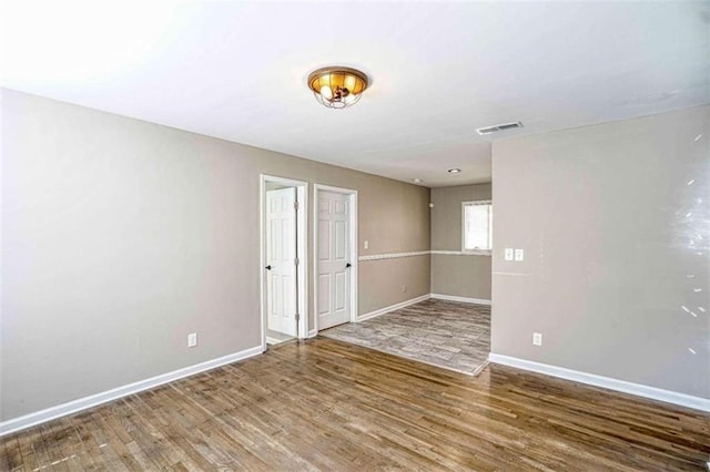 unfurnished room with wood-type flooring