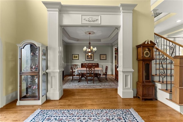 4645 Manor Dr, Gainesville, GA 30506 - foyer with ornate columns, light wood finished floors, a chandelier, ornamental molding, and wainscoting