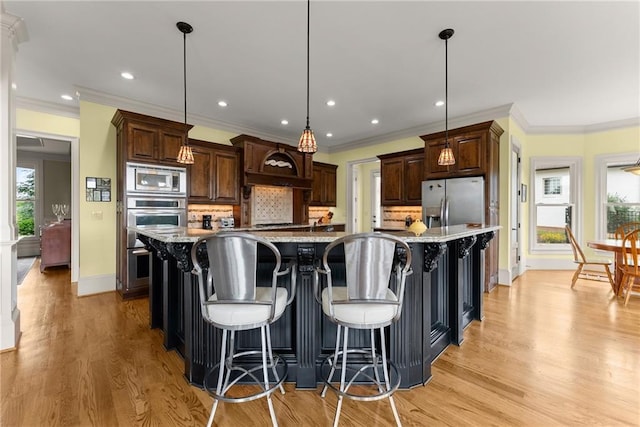 4645 Manor Dr, Gainesville, GA 30506 - kitchen featuring stainless steel appliances, backsplash, light wood finished floors, a spacious island, and baseboards