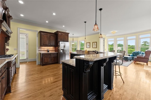 4645 Manor Dr, Gainesville, GA 30506 - kitchen with appliances with stainless steel finishes, ornamental molding, decorative backsplash, light wood-style floors, and a breakfast bar