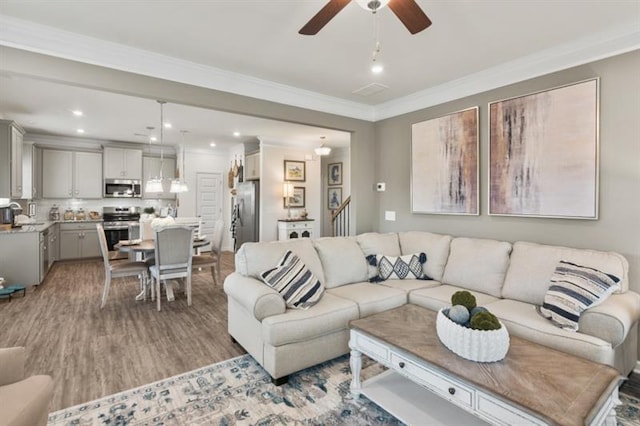 living room featuring wood finished floors, ceiling fan, crown molding, and recessed lighting