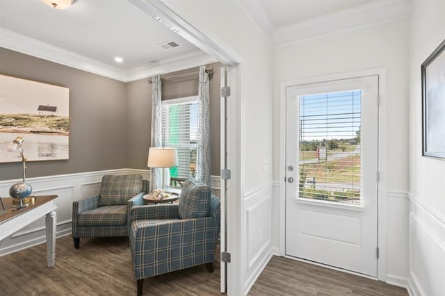 doorway to outside with crown molding, wood finished floors, a decorative wall, and a wainscoted wall