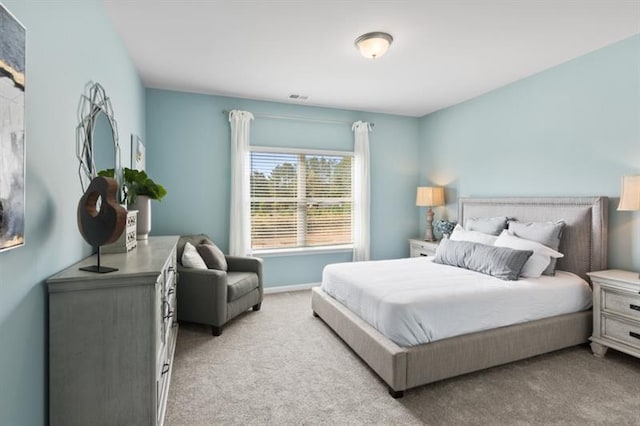 bedroom with light carpet and baseboards