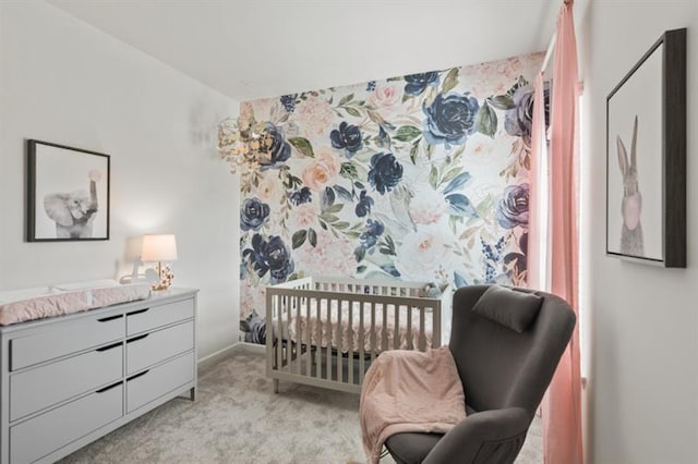 bedroom featuring light carpet, a crib, and baseboards