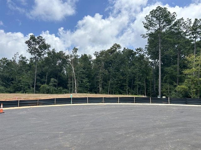view of parking featuring a forest view