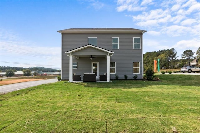 view of front of property with ceiling fan and a front lawn