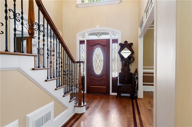 entryway featuring plenty of natural light, a high ceiling, visible vents, and wood finished floors