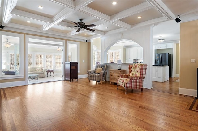 sitting room featuring light wood-style flooring, a healthy amount of sunlight, beamed ceiling, and ceiling fan