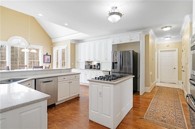 kitchen with a kitchen island, wood finished floors, white cabinetry, stainless steel appliances, and lofted ceiling