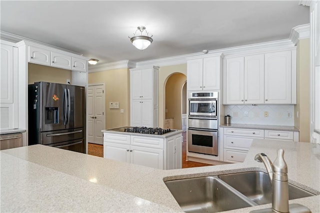 kitchen with gas cooktop, stainless steel fridge with ice dispenser, a sink, white cabinets, and tasteful backsplash