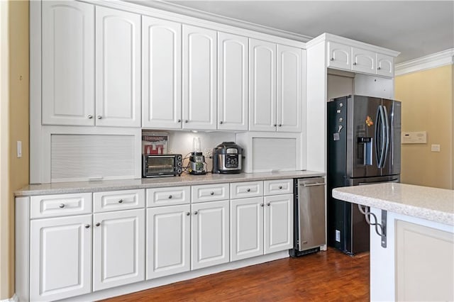 kitchen featuring backsplash, dark wood finished floors, a toaster, white cabinets, and stainless steel fridge