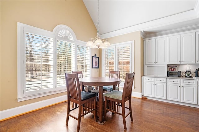 dining space with a chandelier, high vaulted ceiling, dark wood-type flooring, and baseboards