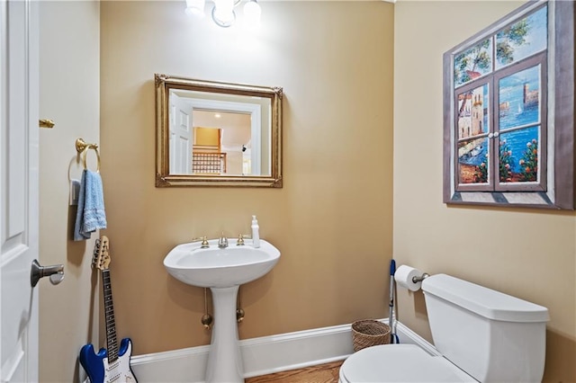 bathroom featuring toilet and baseboards