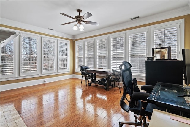 office area with crown molding, wood finished floors, visible vents, and a wealth of natural light