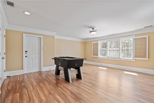 game room featuring light wood-style floors, visible vents, and ornamental molding