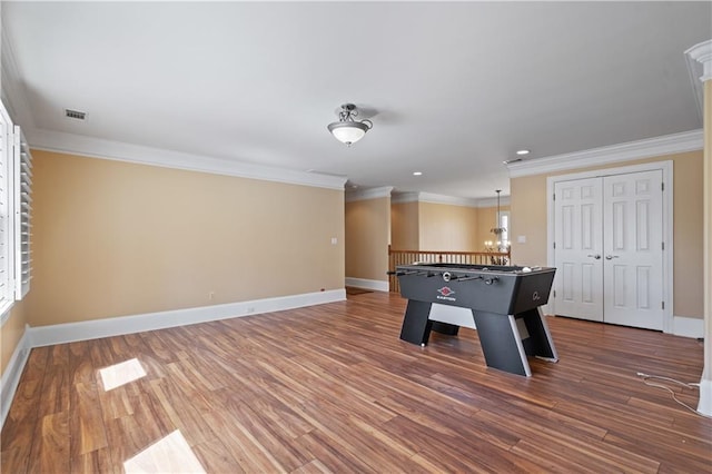 playroom featuring crown molding, baseboards, and wood finished floors