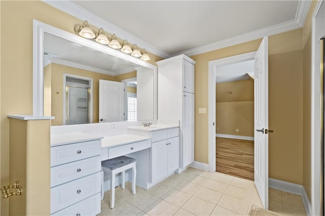 bathroom with tile patterned flooring, crown molding, vanity, and baseboards