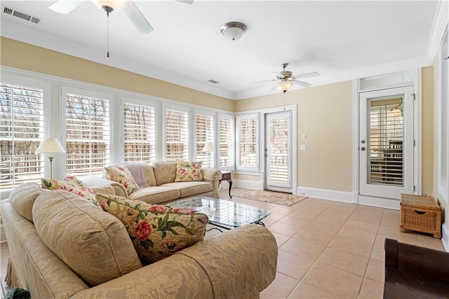 living area with tile patterned floors, visible vents, a ceiling fan, crown molding, and baseboards