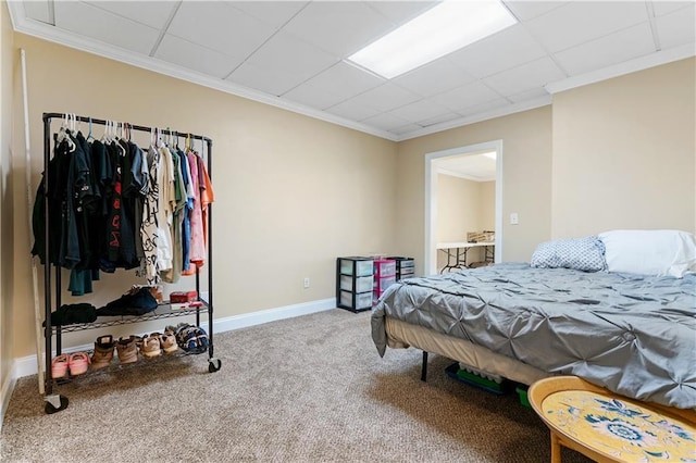 bedroom with a drop ceiling, baseboards, ornamental molding, and carpet flooring