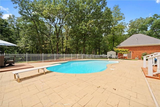 view of pool featuring a diving board, a fenced in pool, a patio area, and fence