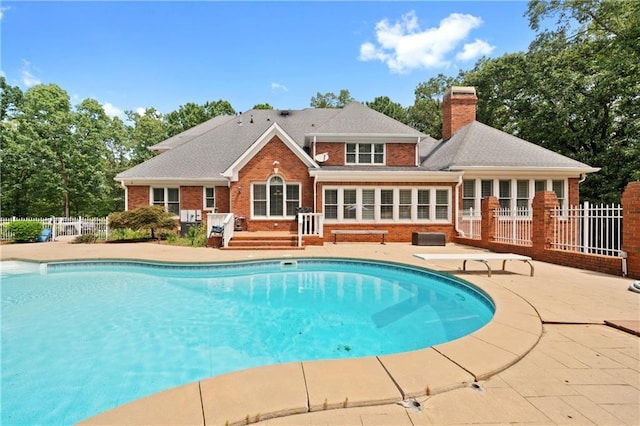 view of pool with a diving board, a fenced in pool, fence, and a patio area