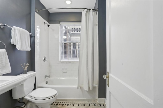 bathroom featuring shower / tub combo, tile patterned flooring, and toilet