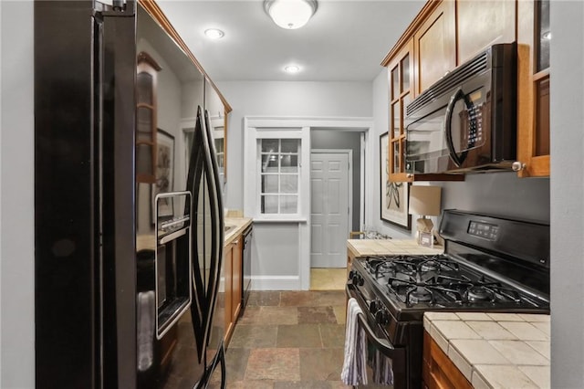 kitchen featuring tile counters and black appliances