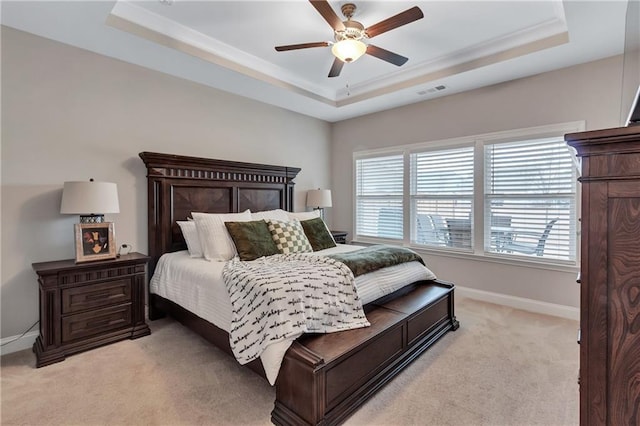 carpeted bedroom featuring a raised ceiling and ceiling fan