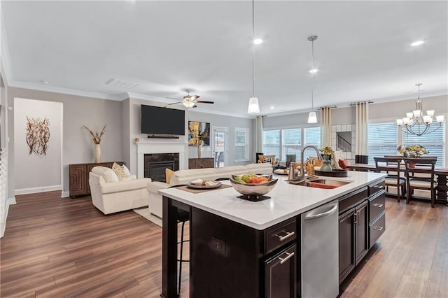 kitchen with a kitchen island with sink, sink, decorative light fixtures, and a kitchen bar