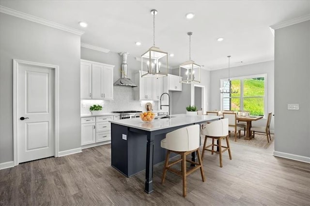 1101 Cooks Farm Way, Woodstock, GA 30189 - kitchen with wall chimney exhaust hood, ornamental molding, a kitchen bar, white cabinets, and wood finished floors