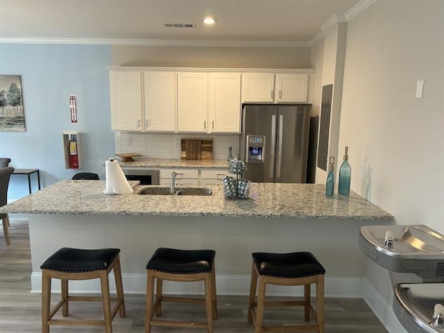 1101 Cooks Farm Way, Woodstock, GA 30189 - kitchen featuring stainless steel fridge, a sink, white cabinetry, light stone countertops, and ornamental molding