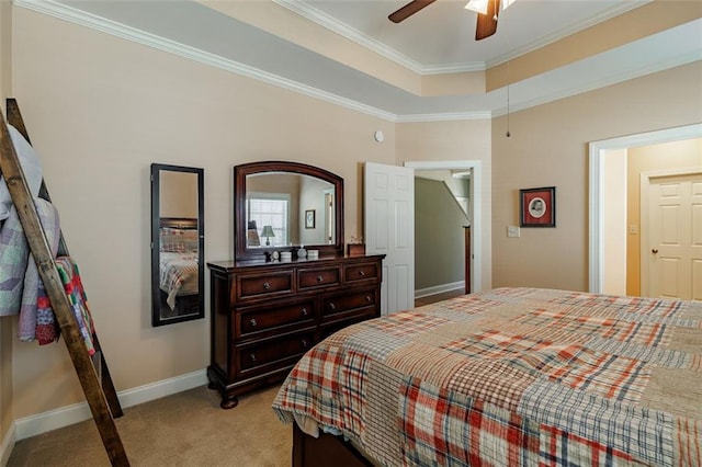 bedroom featuring baseboards, ceiling fan, ornamental molding, a raised ceiling, and light colored carpet