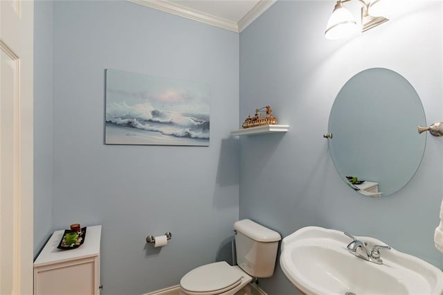 bathroom featuring ornamental molding, toilet, and a sink