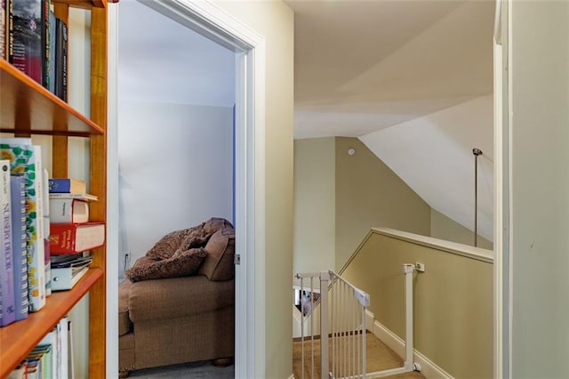 corridor featuring lofted ceiling and an upstairs landing