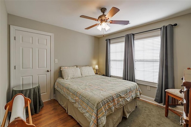 bedroom with wood finished floors, baseboards, and ceiling fan