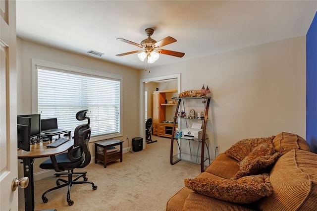 home office featuring ceiling fan, light colored carpet, visible vents, and baseboards