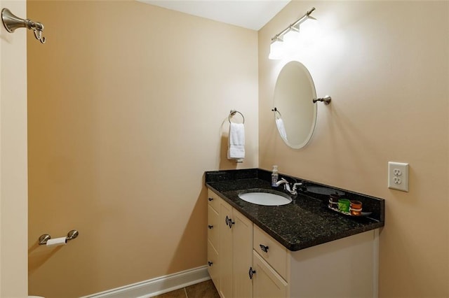 half bathroom featuring tile patterned flooring, vanity, and baseboards