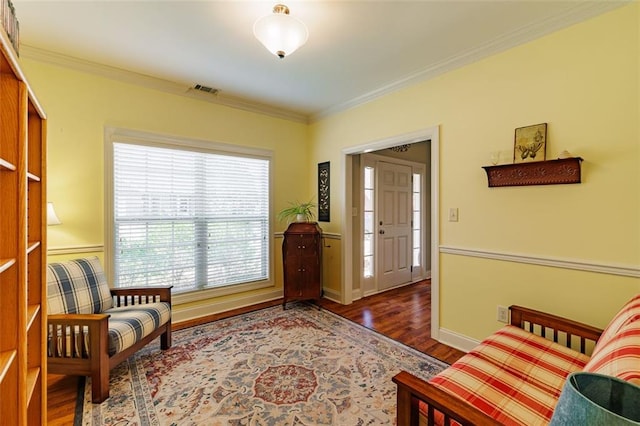 sitting room featuring crown molding, wood finished floors, baseboards, and visible vents