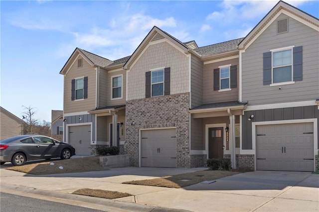 multi unit property with board and batten siding, concrete driveway, and brick siding