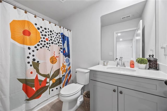 bathroom featuring toilet, curtained shower, vanity, and visible vents