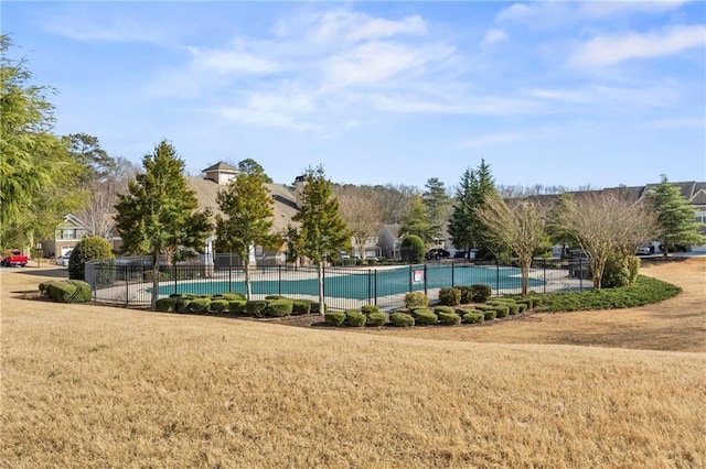 community pool featuring fence and a lawn