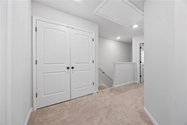 hallway featuring recessed lighting, baseboards, light carpet, and an upstairs landing