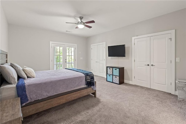 carpeted bedroom featuring ceiling fan, french doors, multiple closets, and access to exterior