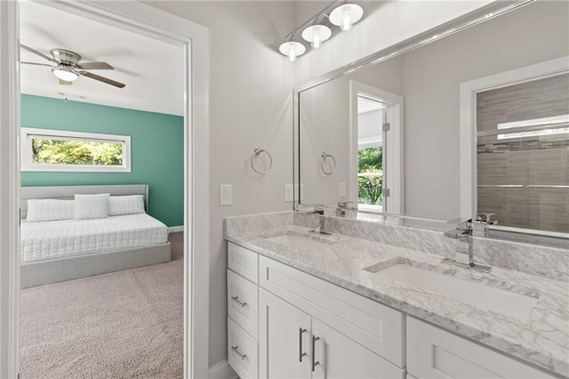 full bathroom with double vanity, baseboards, ceiling fan, and a sink