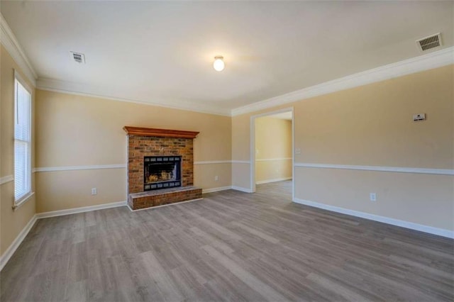 unfurnished living room with visible vents, a fireplace, baseboards, and wood finished floors